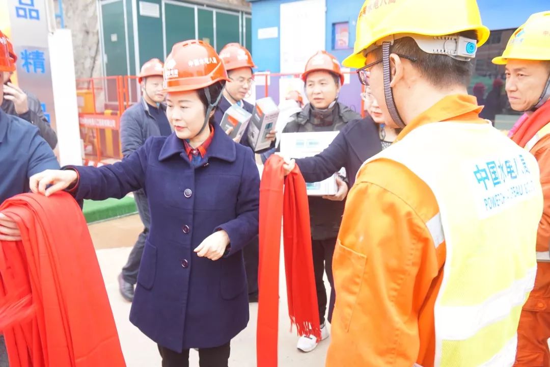 芮英姿为重点工程建设者们系上红围巾、送上保温杯和粮油等慰问物资。图片为通讯员 杨帆 摄