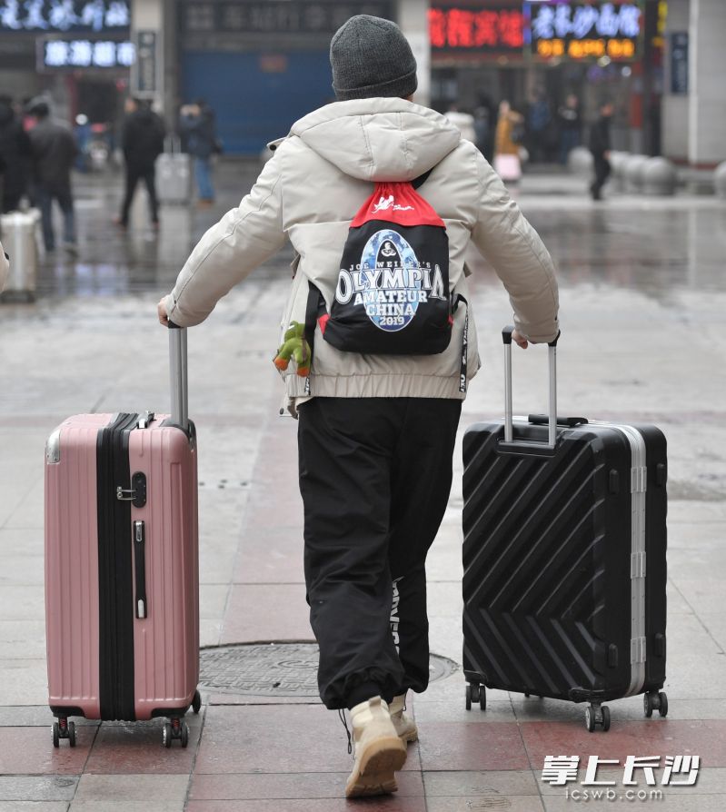 一位旅客一手推一个行李箱，显得很轻松。