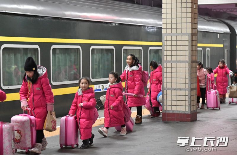 长沙火车站3站台，一群学舞蹈的小朋友每人推着一个行李箱赶火车。