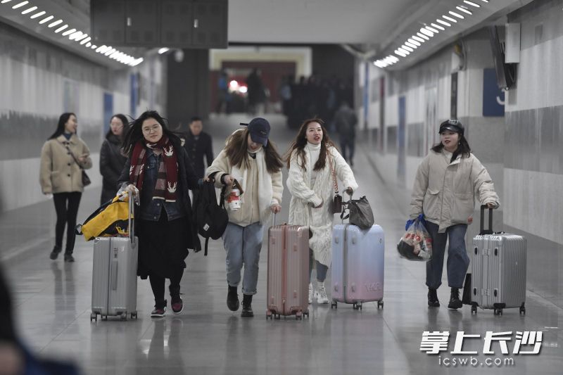 几位赶车的女士，四人全都推着万向轮行李箱。