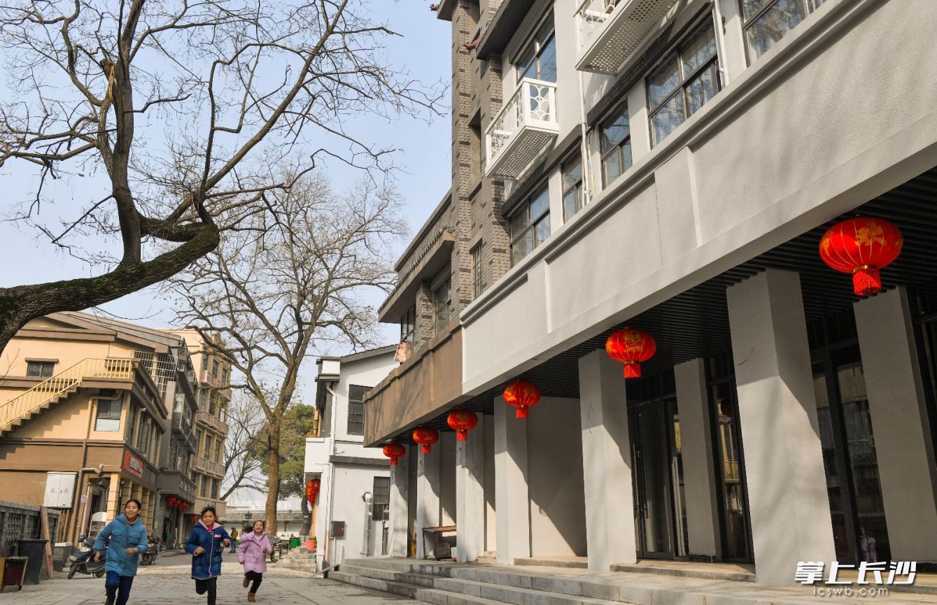1月19日，改造后白沙液街年味渐浓，门前挂满了大红灯笼，孩子们在这里开心的玩耍。