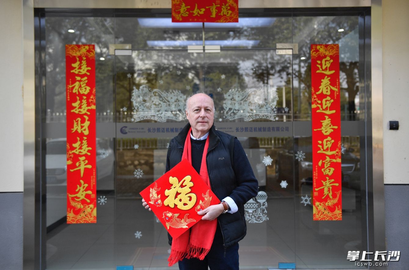 “新年快乐，恭喜发财！”长沙熙迈机械总经理马里奥在公司门口为长沙市民送上新春祝福。长沙晚报全媒体记者 邹麟 摄