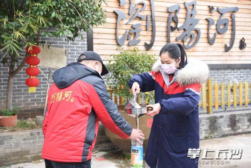 企业工作人员为附近村民装酒精，无偿赠送给他们。