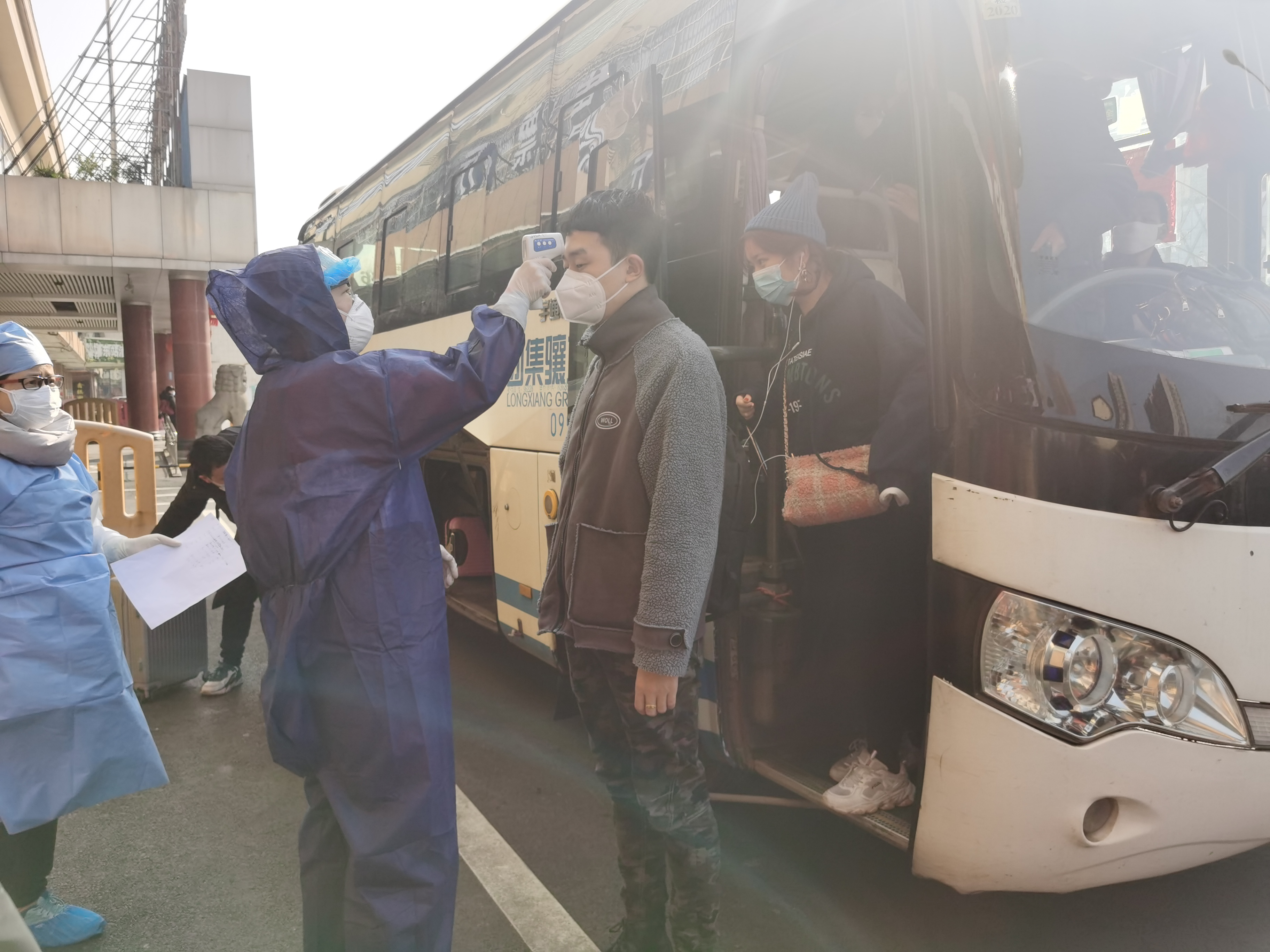 在长沙汽车东站，站内志愿者们会对来长旅客进站第一时间体温检测。