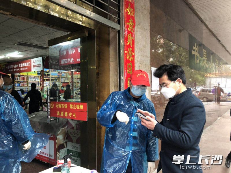 志愿者在指导商户进行居民电子健康卡认证。 长沙晚报通讯员 方彬 摄