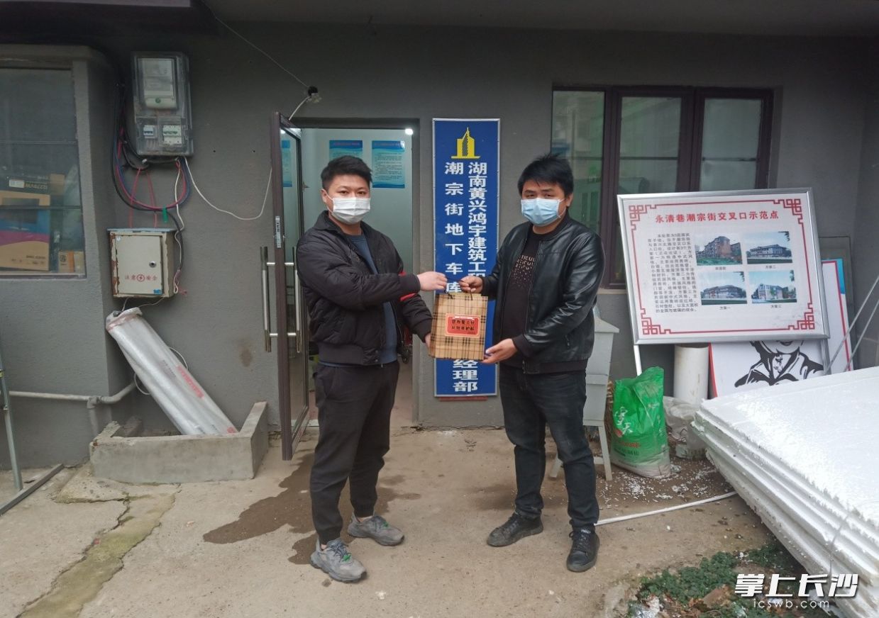 社区干部给施工负责人赠送防疫“复工安全包”。 通讯员 吴祖常 摄