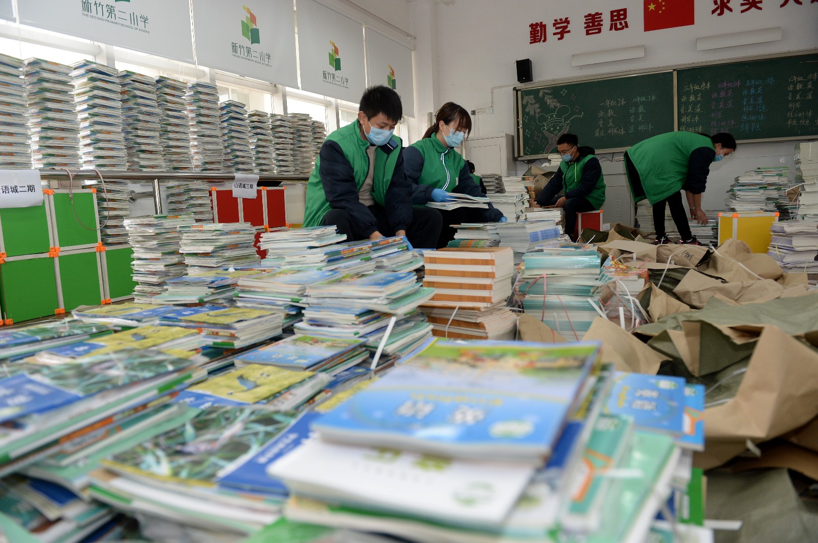 老师根据年级、班级、小区等对新教材分门别类，进行分拣和打包装袋，确保精准派送。长沙晚报全媒体记者
 石祯专 摄
