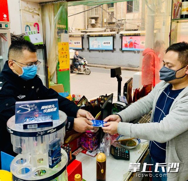民警将禁毒警民联系卡发放给店主。通讯员 左峰 摄