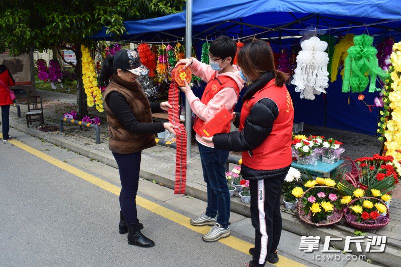 金盆岭志愿者现场指导居民使用电子鞭炮。长沙晚报全媒体记者 王斌 摄