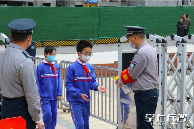 砂子塘启新小学对学生进行消毒和体温检测。