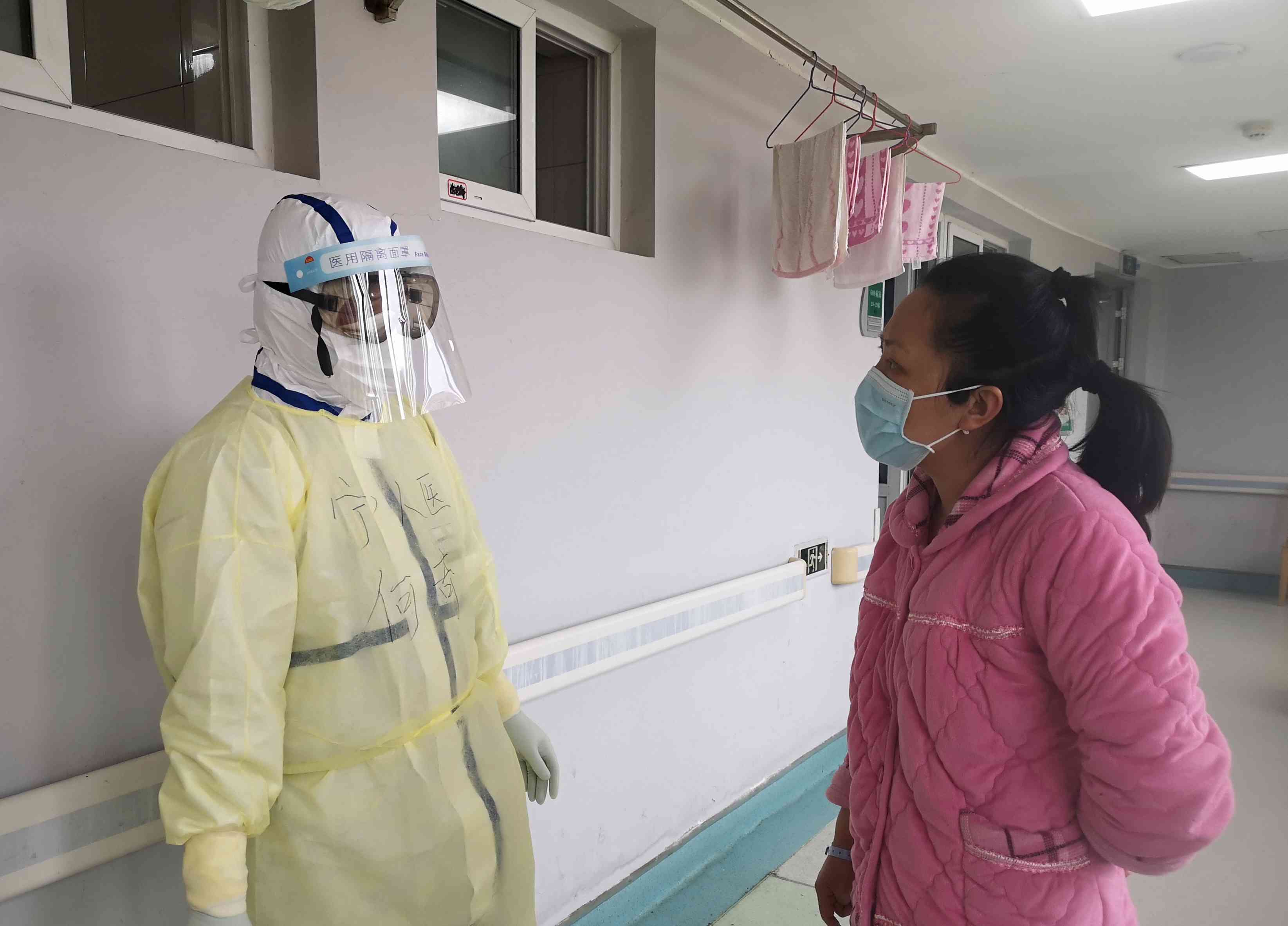 金银潭医院里，何奇在与患者交流。