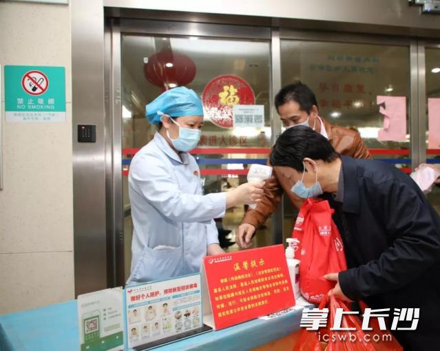 湖南省肿瘤医院医护人员对求诊患者检测体温。医院 供图