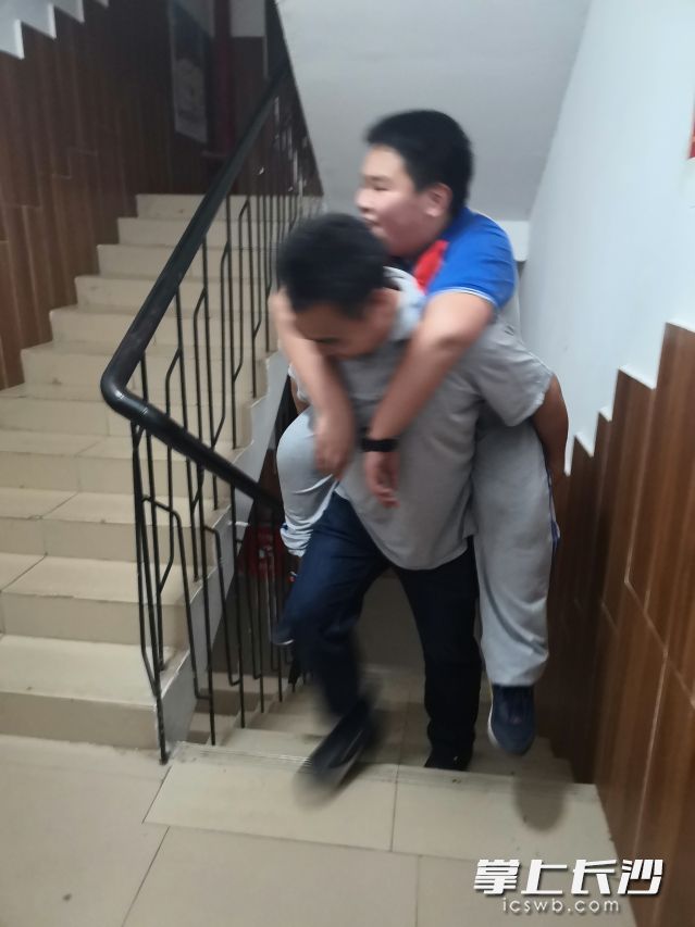 湖南师大附属思沁中学老师聂玲芝在查寝时巧遇了俞轶背受伤学生回寝的暖心一幕。照片在学校教师群转发后，引发热议。学校供图