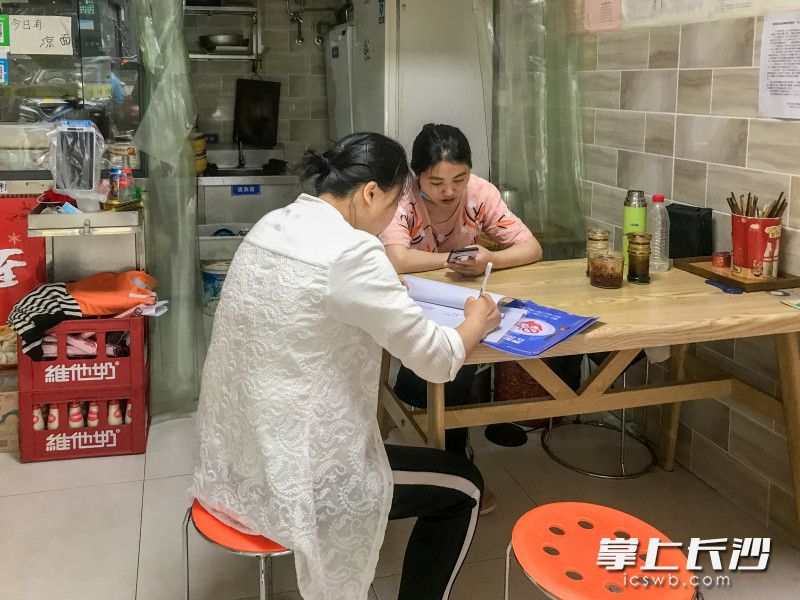 社区网格长在走访辖区门店，了解复工情况。