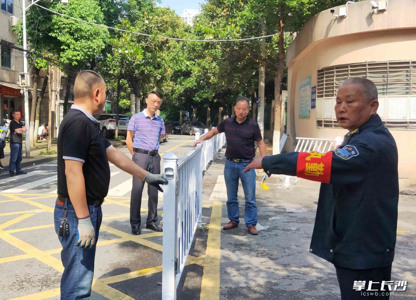 社区工作人员正在用护栏在国庆小学门口建安全通道。长沙晚报全媒体记者 贺文兵 摄