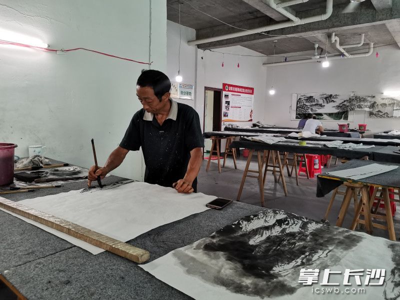 在浏阳市小河乡新河村韵墨缘画室，“农民画师”詹秋明正在画画。长沙晚报全媒体记者 黄能 摄
