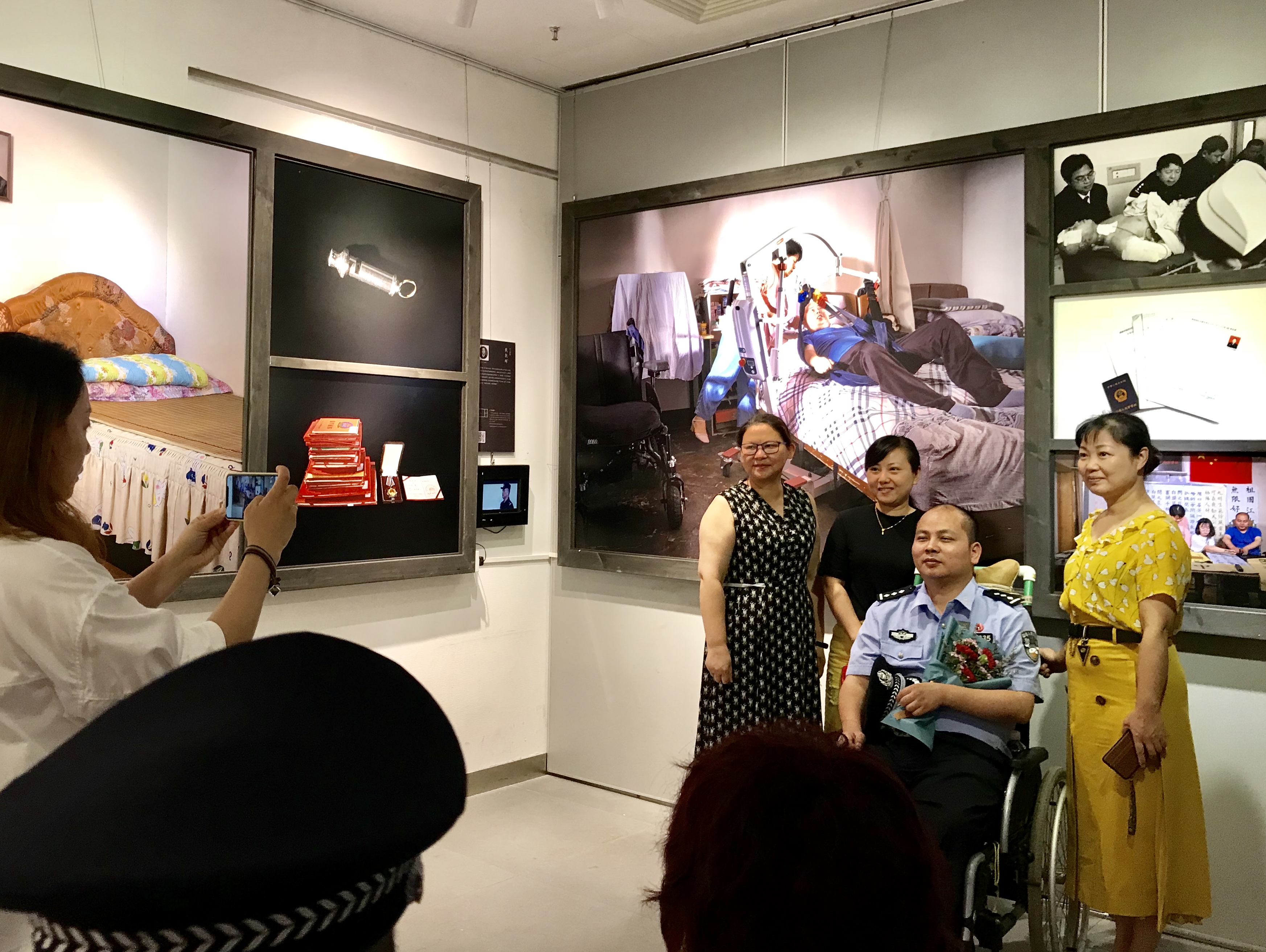 在展览现场，观展者和因公伤残民警谭灿江合影。 长沙晚报全媒体记者 聂映荣 摄