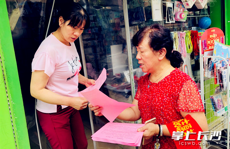 志愿者上长铁一中附近门店发放护考倡议书。