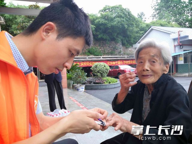 志愿者为老人修剪手指甲。长沙晚报全媒体记者 贺文兵 摄