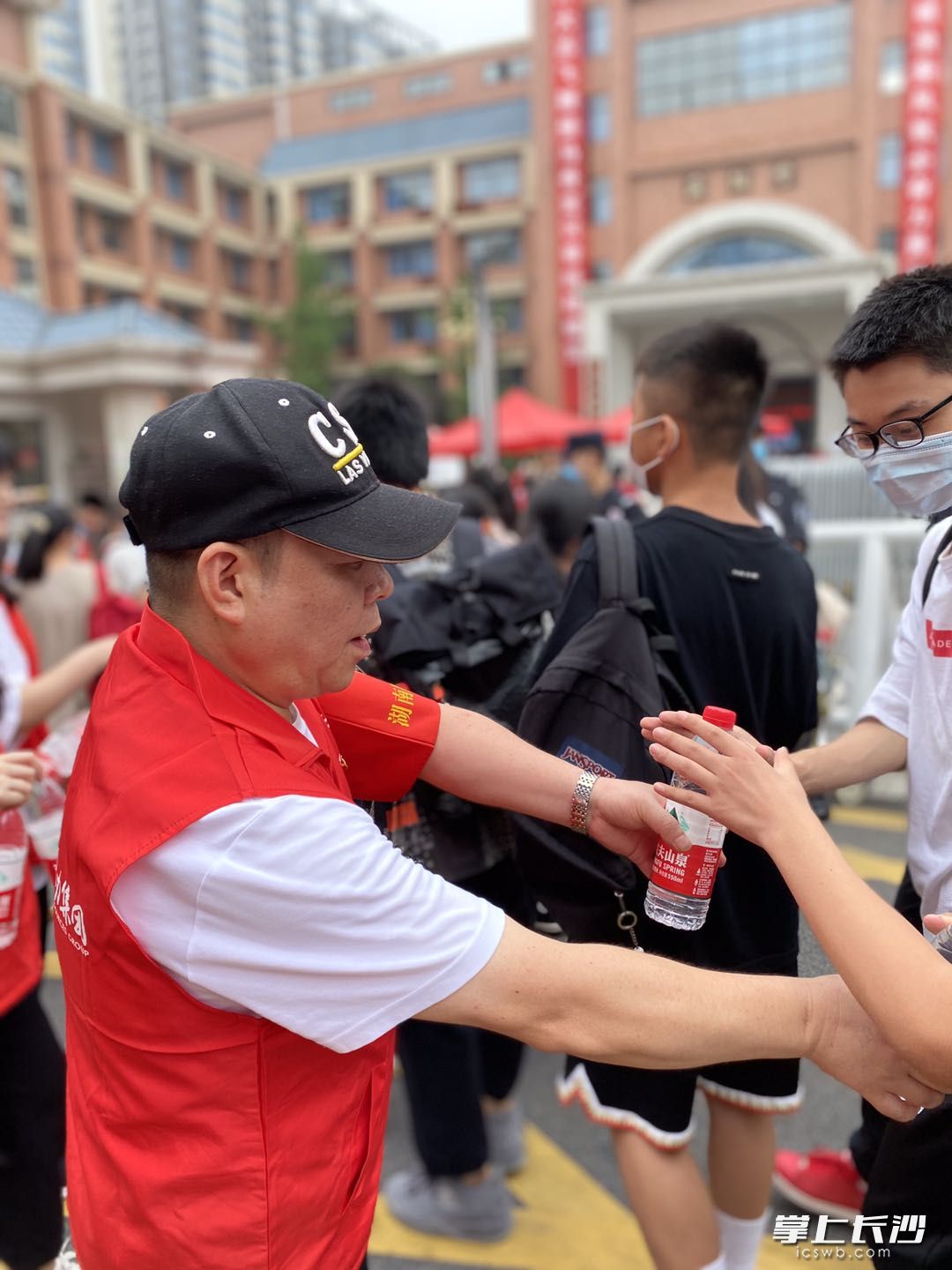 在明德天心中学外，天心区文源街道金汇社区30余名“雷锋志愿者”组成“文源护考志愿服务队”为考生及家长提供贴心志愿服务。长沙晚报全媒体记者 匡春林 实习生 夏瑞婷 摄