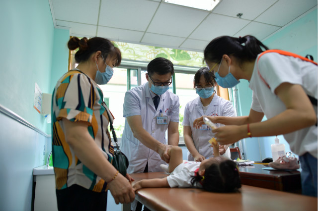 骨科专家梅海波教授耐心地为来自全国各地来院求医的孩子做体格检查。长沙晚报通讯员 李奇 摄 骨科专家梅海波教授耐心地为来自全国各地来院求医的孩子做体格检查。长沙晚报通讯员 李奇 摄