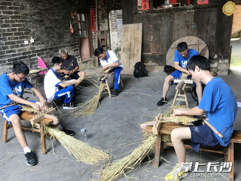 学生跟着老手艺人学编织。