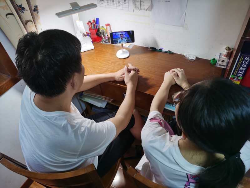 长沙市十一中一位家长和孩子一起收看讲座视频，共同学习与进步。市十一中 供图