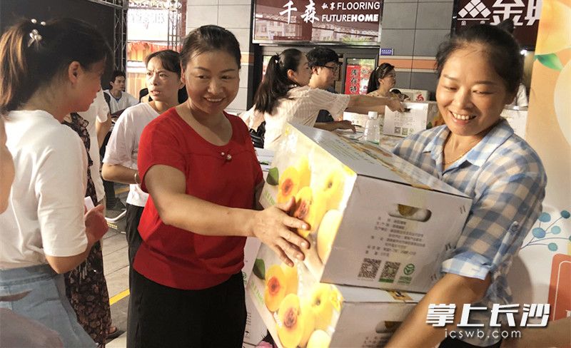 接过派发的爱心黄桃，商户很开心。通讯员 胡思乐 摄