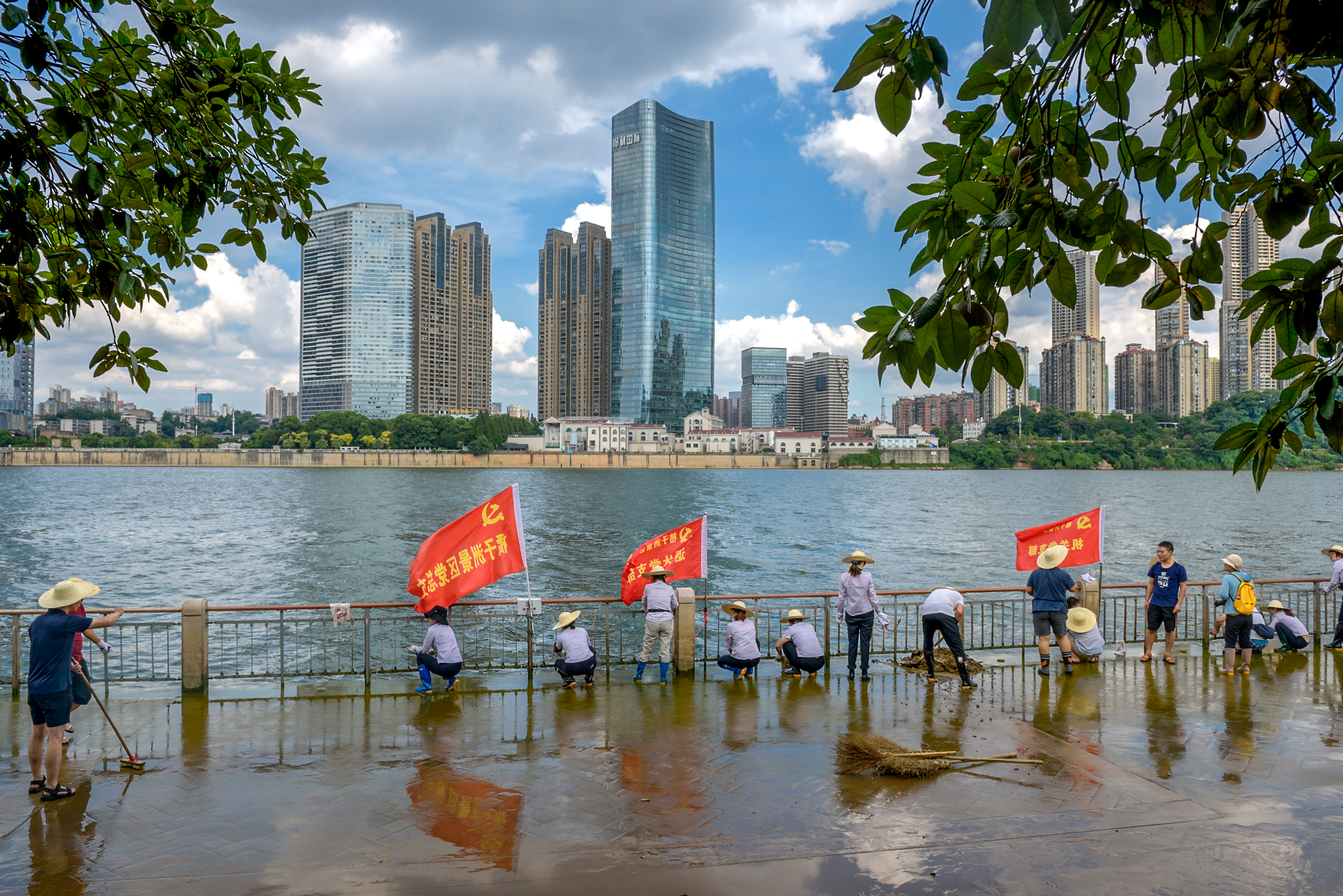 今天下午，橘子洲亲水平台，湘江洪流刚刚退去，地面上积了一层厚厚的淤泥，橘子洲景区管理处工作人员已经开始进行热火朝天清淤工作，水枪、扫把、铲子齐上阵，擦洗栏杆、冲洗地面，忙得不亦乐乎。