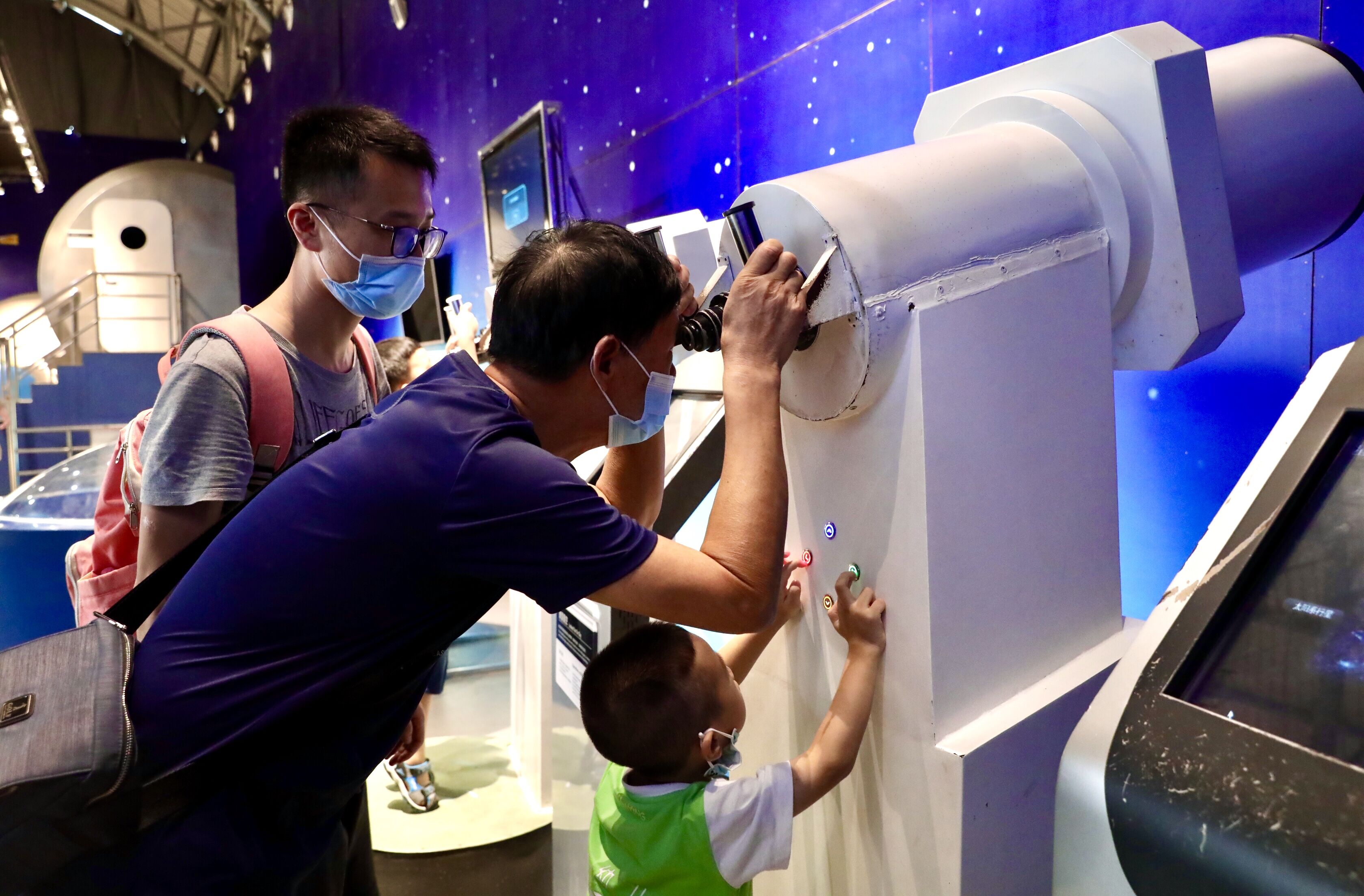 太空探索区内，爷孙三代观看宇宙的奥秘