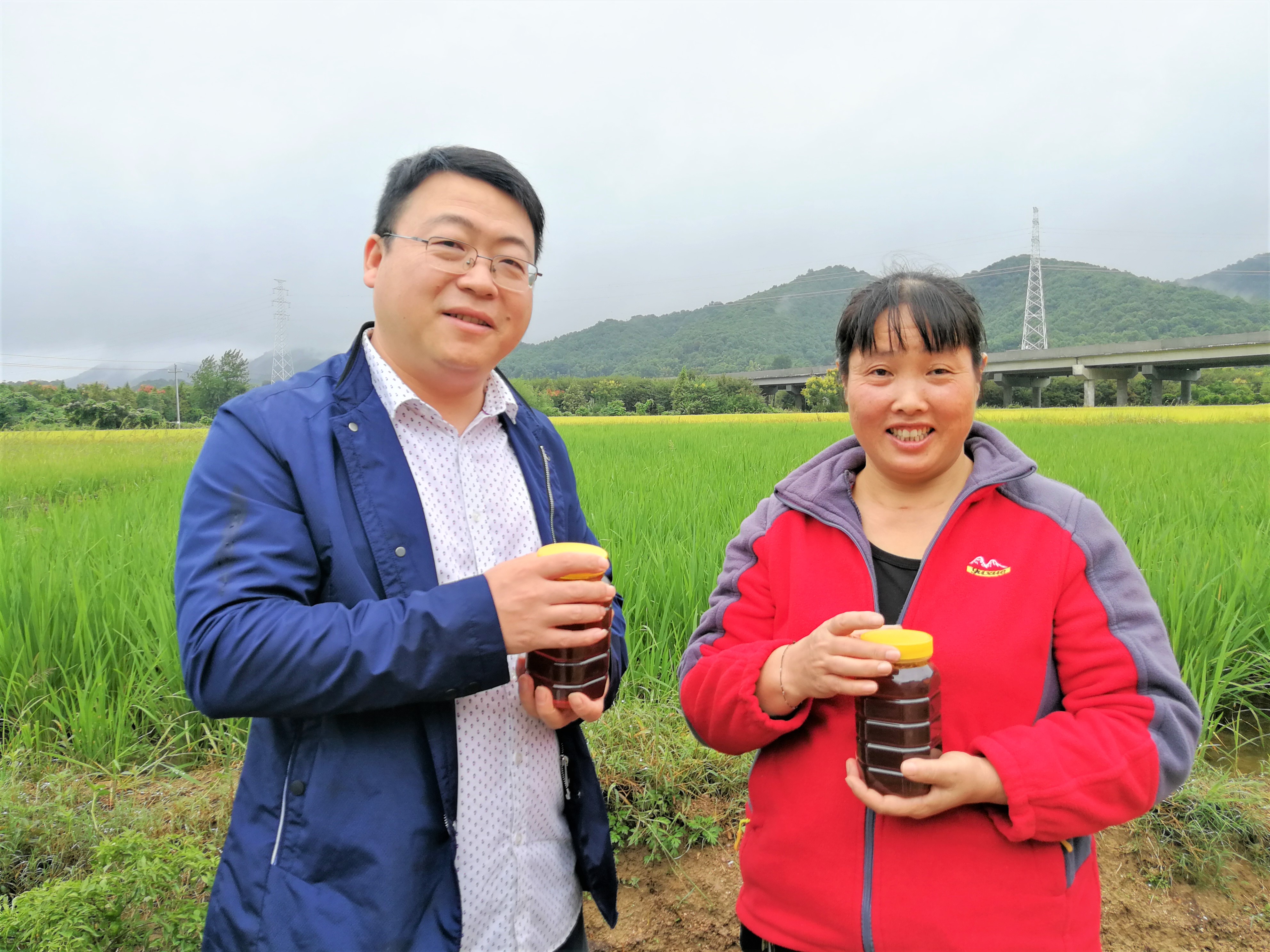 在长龙新村驻村第一书记周文超（左一）的帮助下，贫困户潘群芳靠着养蜂脱贫。均为长沙晚报全媒体记者张禹摄