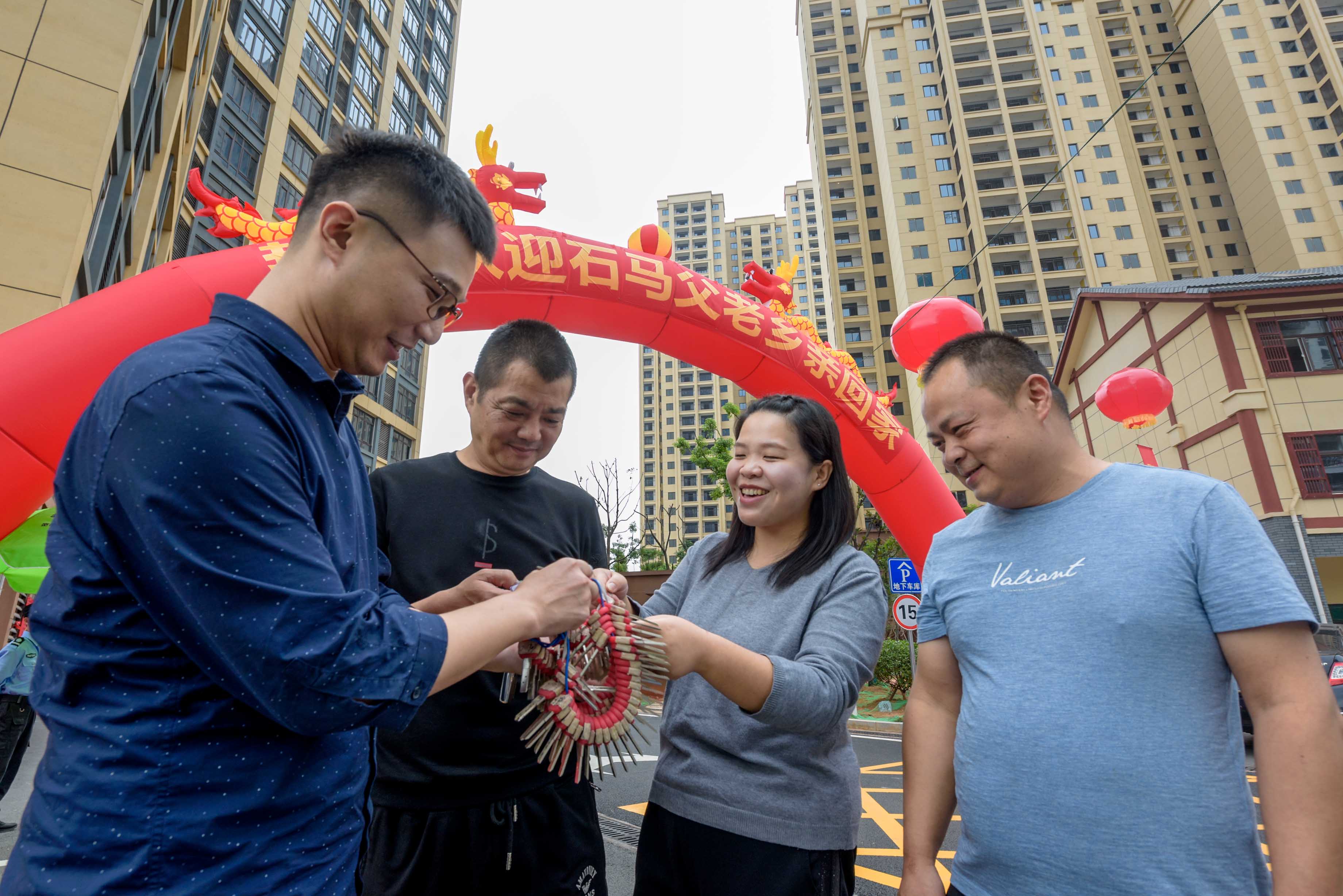  雨花区石马雅苑保障性住房一期内，回迁居民开心地从工作人员手中领取新家钥匙。 长沙晚报全媒体记者  陈飞 摄