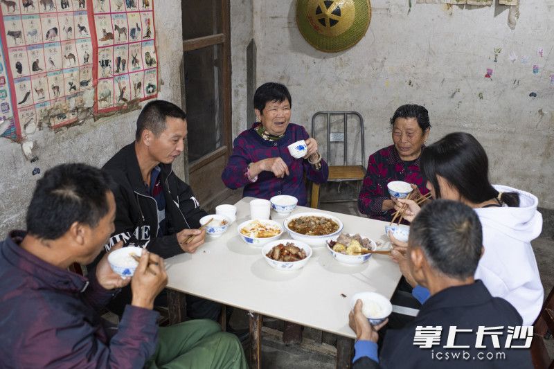 中秋节佳节，黄材镇黄材村脱贫户何义成邀请邻居一起吃团圆饭，日子越过越好。长沙晚报全媒体记者 邹麟 摄