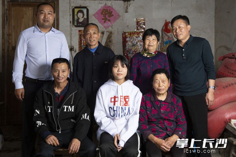 中秋佳节，何义成（前左一）和帮助他的扶贫干部一起拍了一张全家福。长沙晚报全媒体记者 邹麟 摄