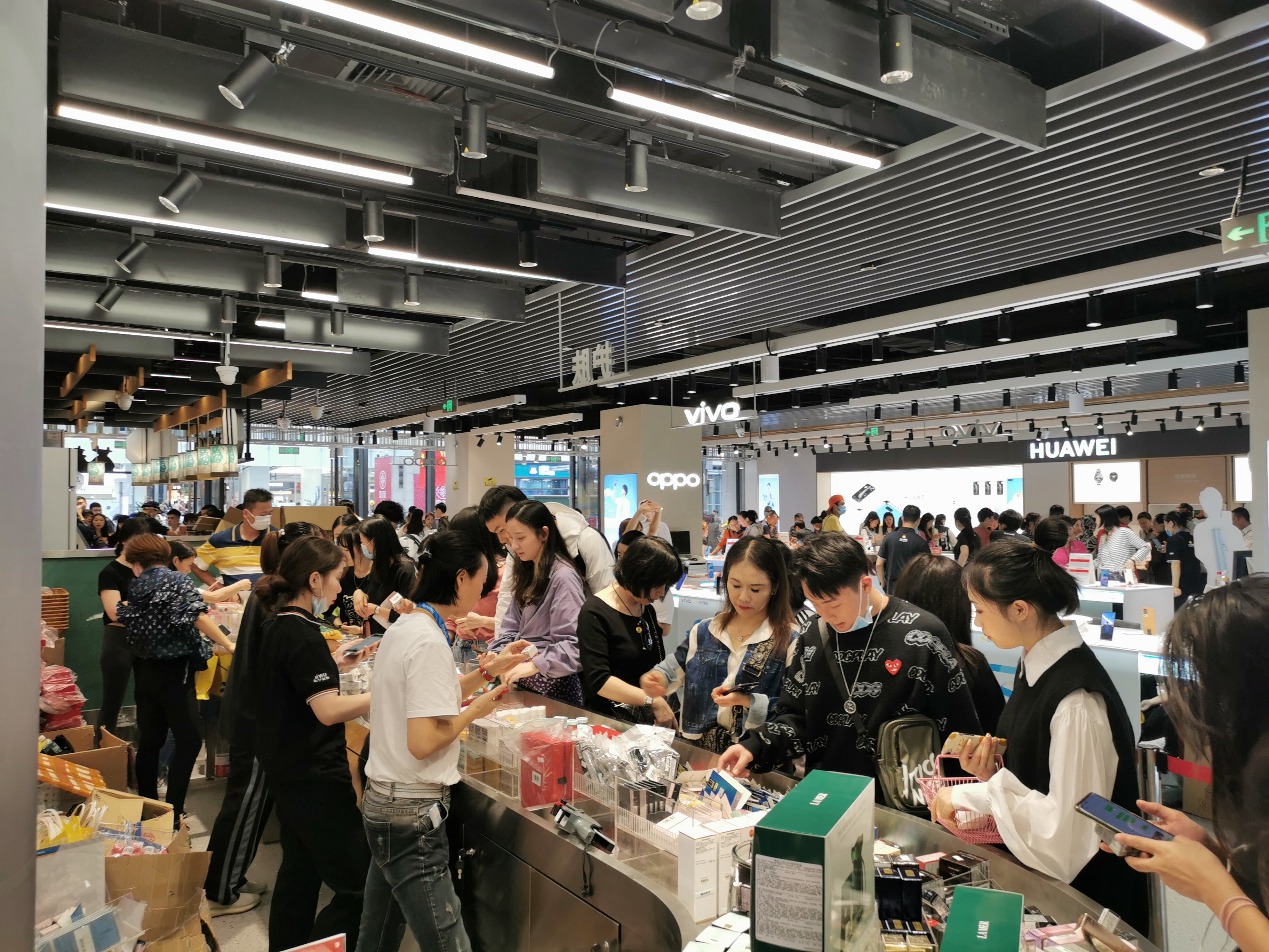 苏宁易购五一云店美妆柜台前选购的市民。