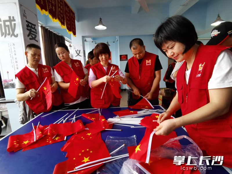 老师志愿者与家长志愿者一起准备国旗。