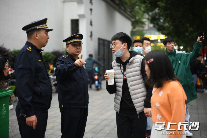 10月6日，下午5时30分，在太平街口，天心区城管执法大队坡子街中队队员吴乐平在为过往的行人指路。