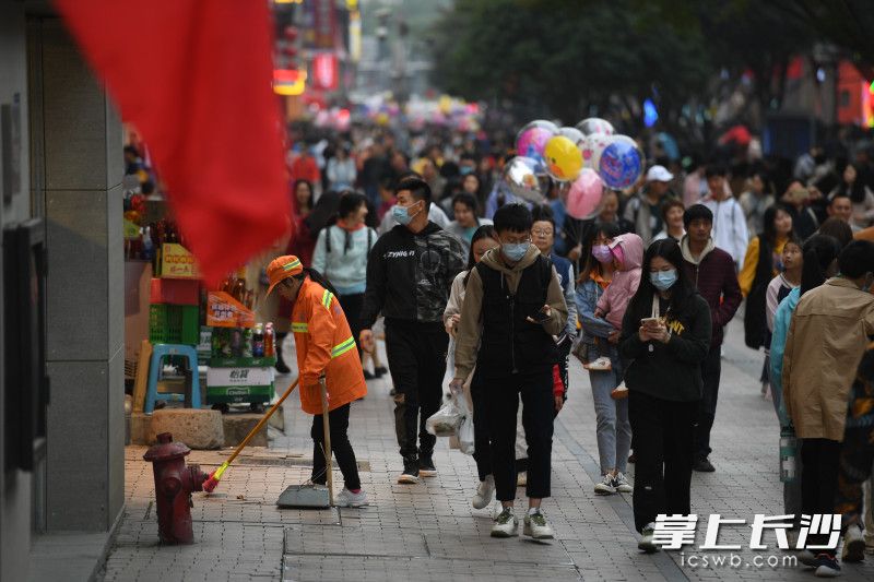 在黄兴南路步行商业街，环卫工人在清扫路面。