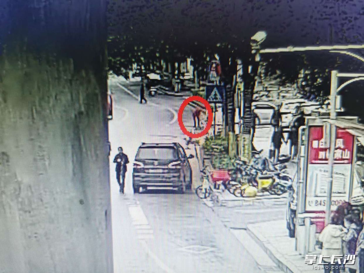 监控显示，一名红衣女子捡了老人丢失的腰包。 警方供图