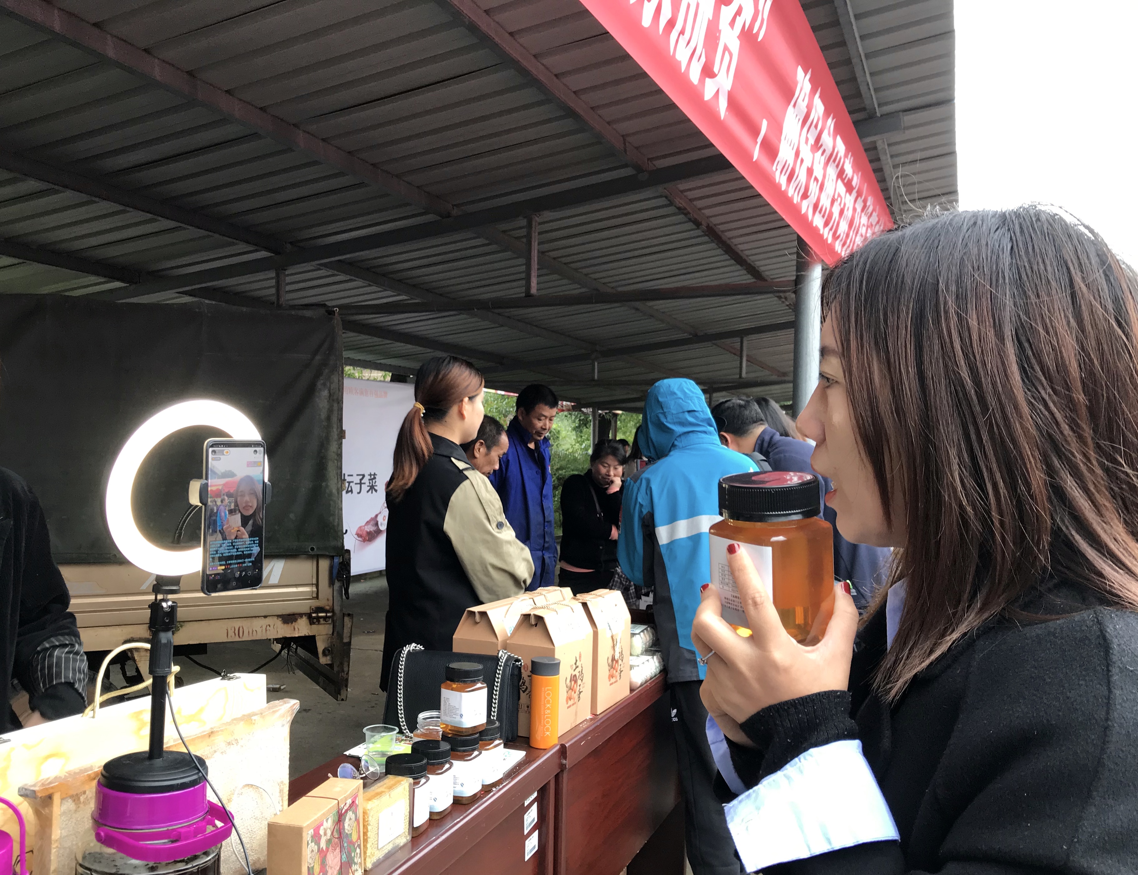 陈彩华正端着一瓶山花蜜在直播带货，这些蜂蜜都是由坝塘镇脱贫户们养蜂所酿。 长沙晚报全媒体记者 聂映荣 摄