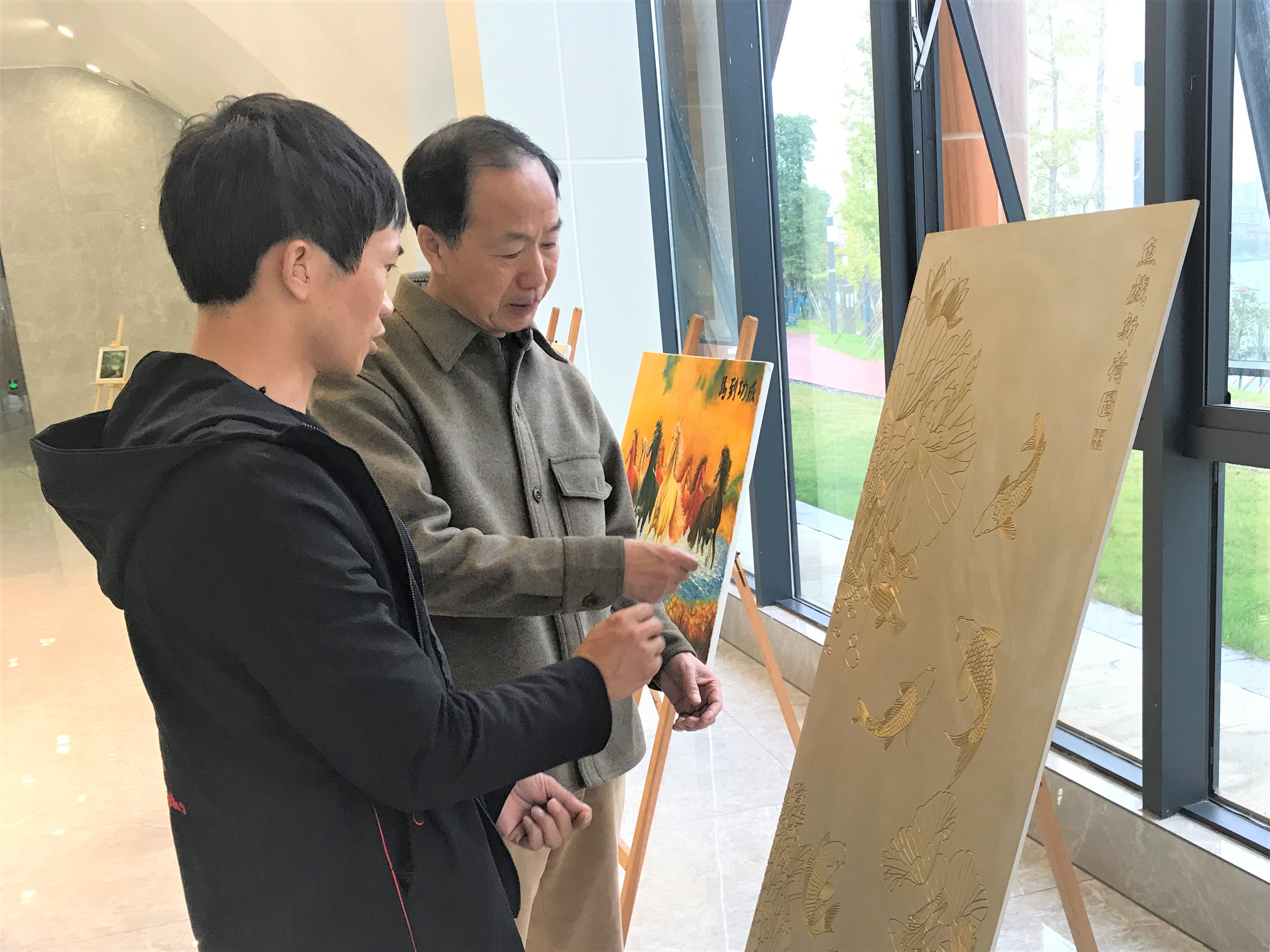 湖南省美术家协会主席、湖南师范大学美术学院院长朱训德（左二）来到画展现场，对肖明进行指导，圆了他心里渴望得到名师指导的夙愿。长沙晚报全媒体记者 张禹 通讯员 陈燕 摄影报道