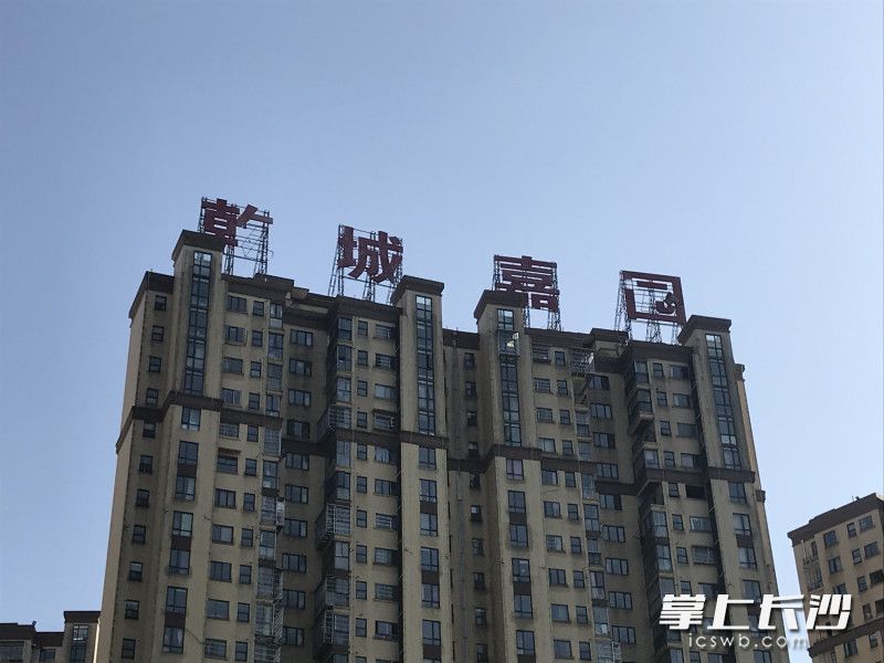 广告牌上的“乾”和“园”字已经掉落了部分笔画。