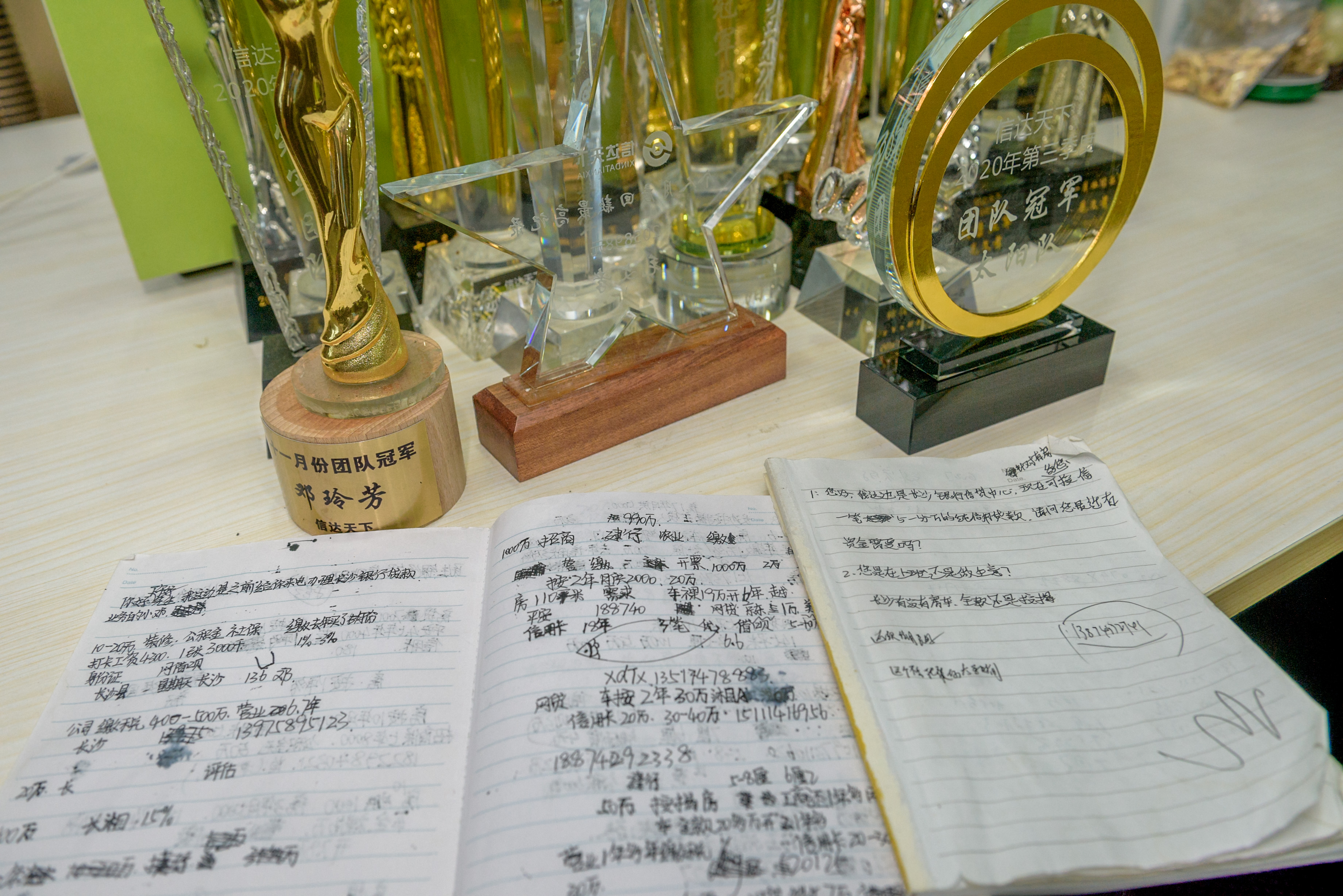 执法人员发现，一家挂牌“商务信息咨询”的企业，员工笔记本上却写满如何以银行名义放贷揽客的话术。  长沙晚报全媒体记者 陈飞 摄