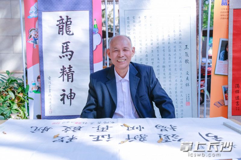 社区居民在雨花区全民终身学习活动周启动仪式现场展示自己的书法作品。