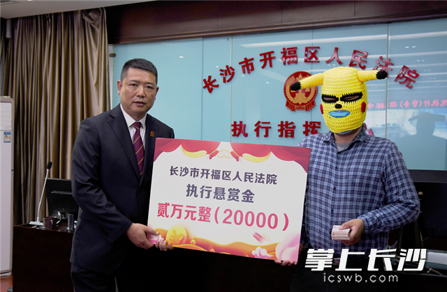 举报人头戴皮卡丘面罩领取执行悬赏金。开福法院供图