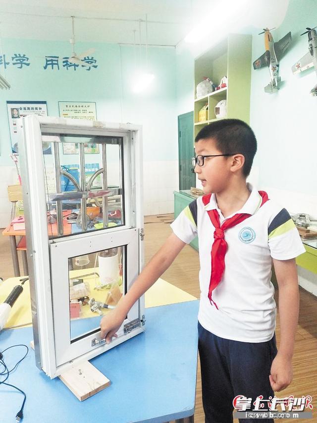 张荣景讲解其发明的“连动互换防护窗”。