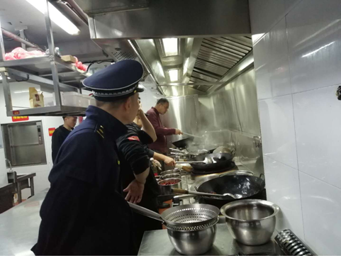 执法人员在餐饮门店厨房进行检查。