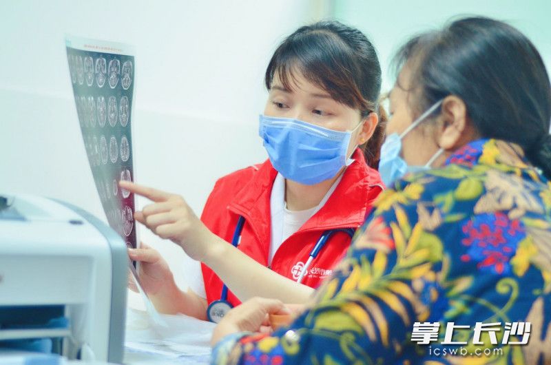 眩晕诊疗中心副主任医师余孝君（左）在向眩晕症患者解释相关检查结果。 医院供图
