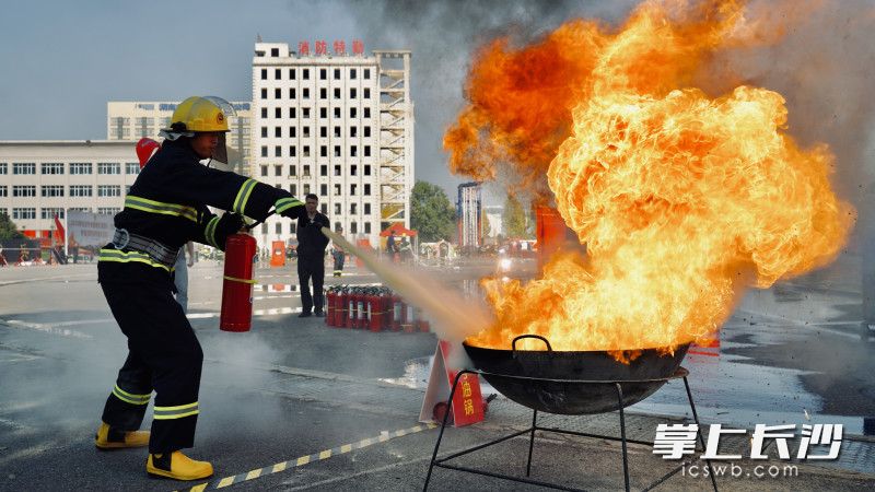 灭火器油锅接力灭火操项目中，参赛队员用灭火器扑灭油锅中的大火。均为长沙晚报通讯员 谢海鹏 摄