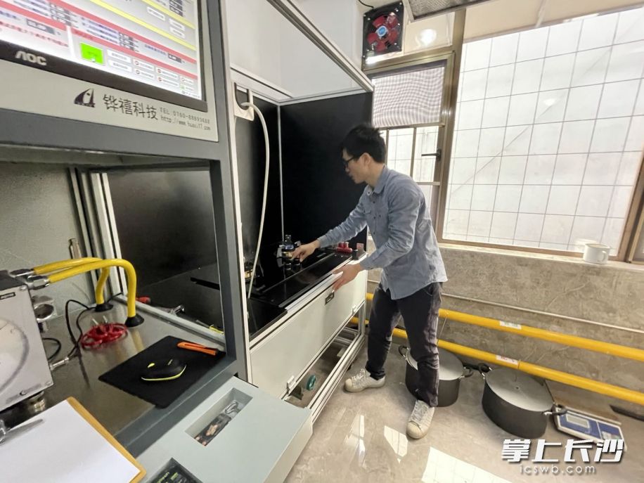 湖南省长沙燃气燃具监督检测中心实验室，周祥正在对燃气灶进行检测。（全媒体记者 唐朝昭 摄）
